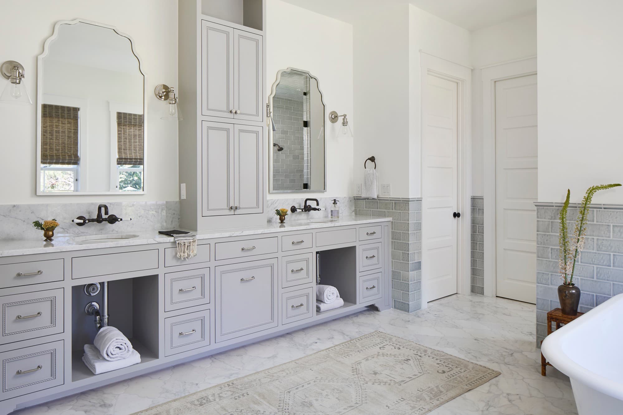 Modern bathroom with gray cabinetry and marble flooring